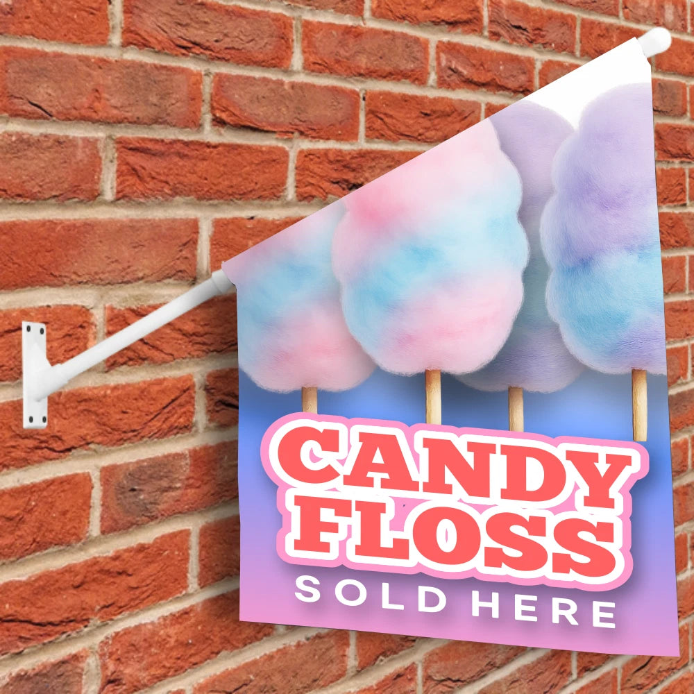 Decorative sign with candy floss design and 'Candy Floss Sold Here' text on a brick wall.